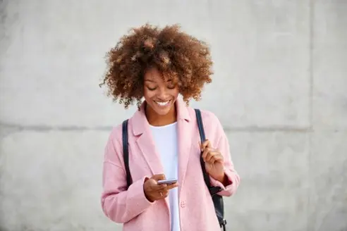 a person on the street looking at their phone, a bubble with an icon of a door floating away from their phone